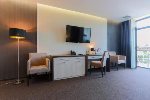 a room with a desk with chairs and a flat screen tv at WISH Aqua&SPA Resort in Vishenki