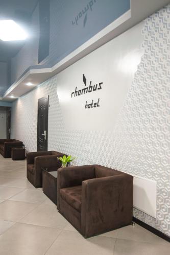 a lobby with brown couches and a sign on a wall at Rhombus Hotel in Luts'k