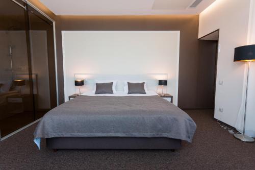 a bedroom with a large bed with two pillows at WISH Aqua&SPA Resort in Vishenki