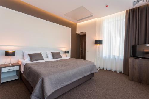 a bedroom with a large bed and a television at WISH Aqua&SPA Resort in Vishenki