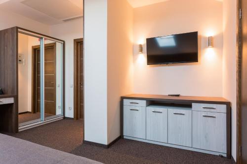 a room with a television on a wall with a counter at WISH Aqua&SPA Resort in Vishenki