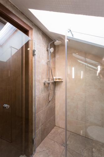 a bathroom with a shower with a glass door at WISH Aqua&SPA Resort in Vishenki