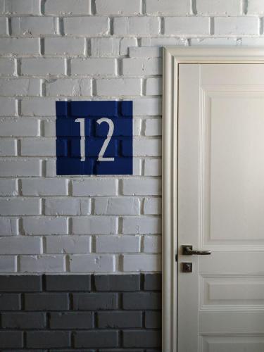 a blue sign on a brick wall next to a door at ololoFreelander Hostel&Coworking in Bishkek