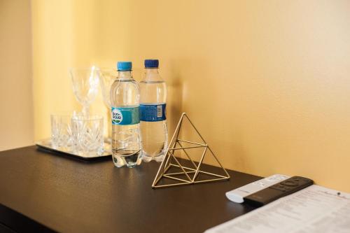 two bottles of water and glasses on a table at Rhombus Hotel in Luts'k