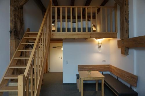 Eine Treppe führt zu einem Zimmer mit einem Tisch. in der Unterkunft Hotel Alter Hafenspeicher in Stralsund