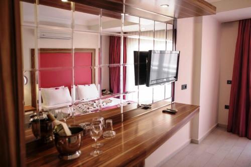 Zimmer mit großem Spiegel und TV in der Unterkunft Cle Beach Boutique Hotel in Marmaris