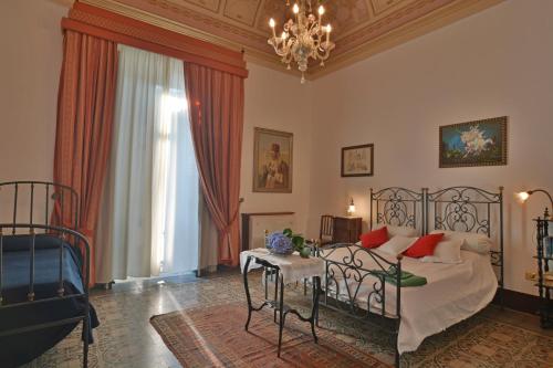 een slaapkamer met een bed en een tafel bij B&B di Charme Camelie in Riposto