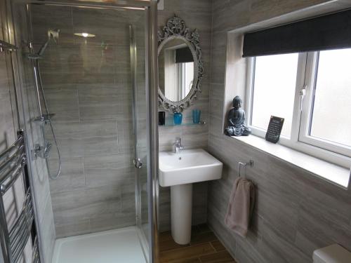 a bathroom with a shower and a sink and a mirror at Parkside Apartments in Newcastle upon Tyne