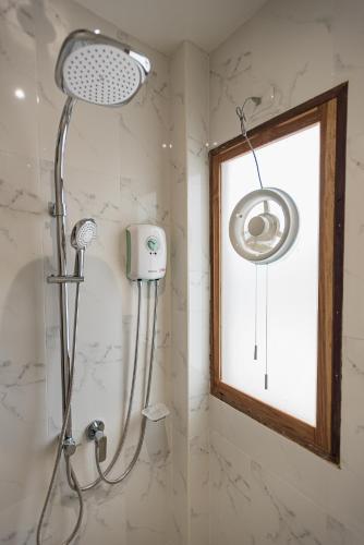 a shower with a shower head in a bathroom at U Chiangkhan in Chiang Khan