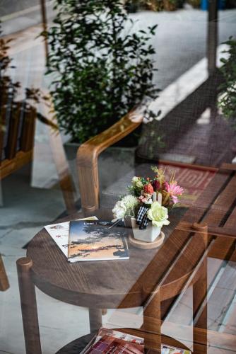 a wooden table with flowers and a book on it at U Chiangkhan in Chiang Khan