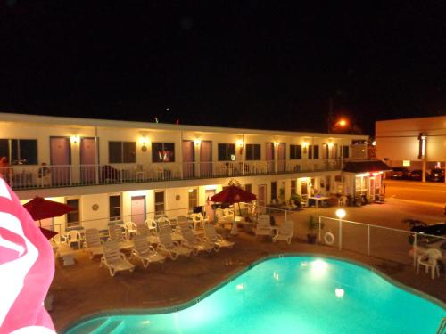 a hotel with a swimming pool at night at Fountain Motel in Wildwood