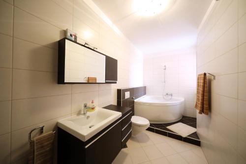 a white bathroom with a sink and a toilet at EasyLiving House near Zadar in Posedarje