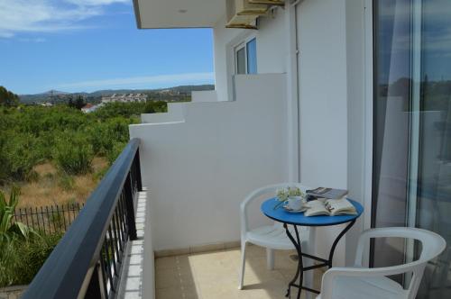 a balcony with a blue table and two chairs at Kostas Studios in Faliraki