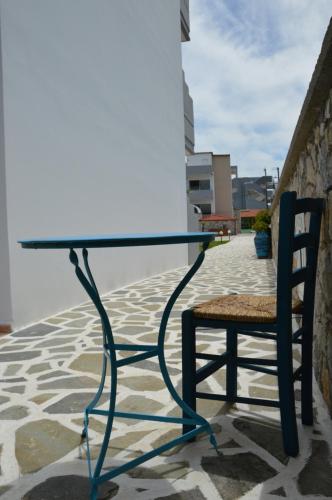 a glass table and a chair on a patio at Kostas Studios in Faliraki