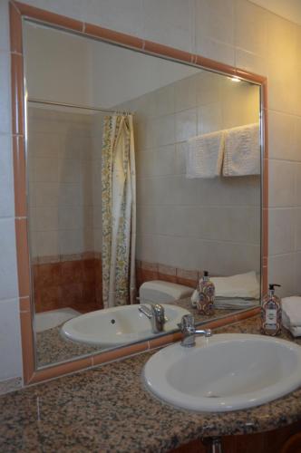 a bathroom with a sink and a tub and a mirror at Kostas Studios in Faliraki