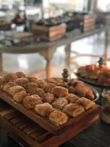 a bunch of pastries on a wooden tray on a table at Litohoro Olympus Resort Villas & Spa in Plaka Litochorou