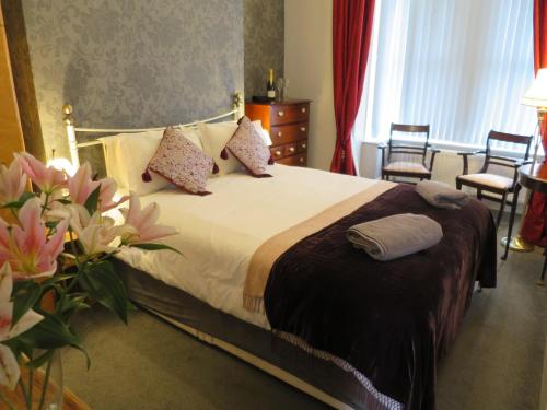 a bedroom with a large bed with pillows and flowers at Parkside Apartments in Newcastle upon Tyne