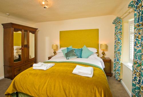 a bedroom with a large bed with towels on it at Cottage Retreat near Peak District and Chatsworth House in Matlock