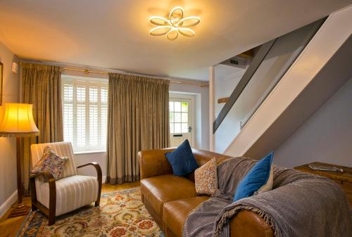 a living room with a couch and a chair at Charming Cottage Near Peak District & Chatsworth in Matlock