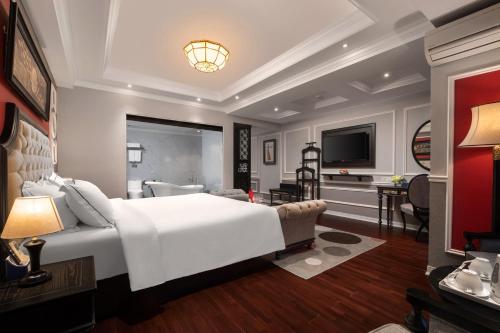 a bedroom with a large white bed and a television at Acoustic Hotel & Spa in Hanoi