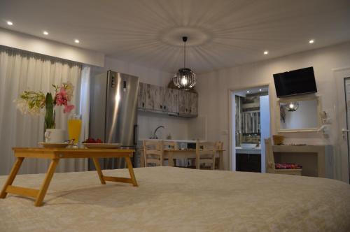 a bedroom with a large bed with a table and a kitchen at Kostas Studios in Faliraki