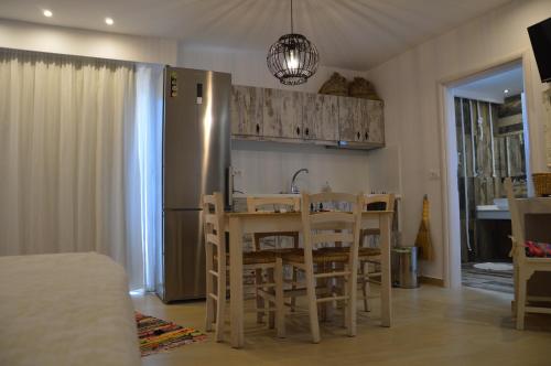 a kitchen with a table and chairs and a refrigerator at Kostas Studios in Faliraki