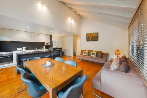 a kitchen and living room with a wooden table and chairs at Southern Ocean Villas in Port Campbell