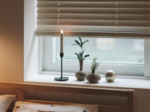 a window sill with a candle and vases on it at Neat House in Seoul