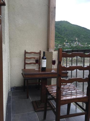 a table with two glasses of wine on a balcony at Apartment Jorjo Mestia in Mestia
