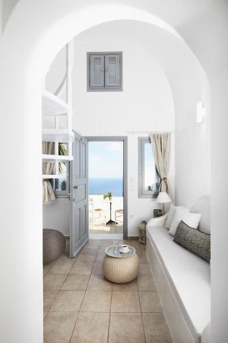 a living room with a white couch and a table at Golden East in Imerovigli