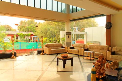 a large living room with couches and a large window at Hotel Ashoka in Rāmeswaram