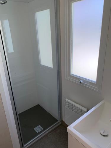 a shower with a glass door in a bathroom at Camping Manaysse in Moustiers-Sainte-Marie