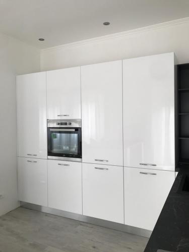 a white kitchen with white cabinets and a microwave at Roof Top 19 in Ventimiglia