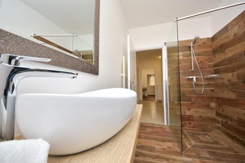 a bathroom with a white sink and a glass shower at Kuća za odmor L&L in Bibinje