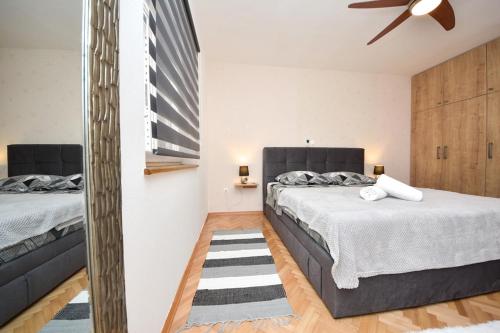 a bedroom with two beds and a ceiling fan at Kuća za odmor L&L in Bibinje