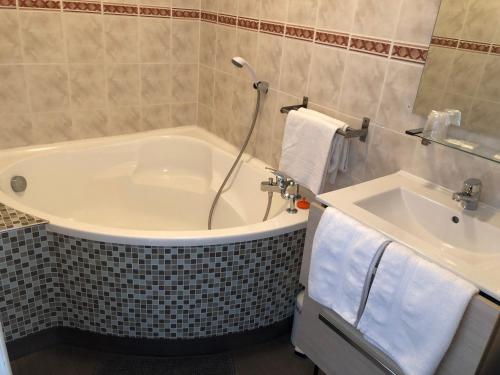 a bathroom with a tub and a sink at Le petit poucet in Saint Lo