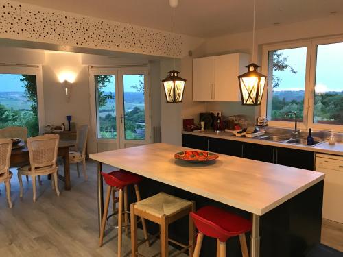 une cuisine avec une grande table et des chaises en bois dans l'établissement La Coulee Verte, à Saint-Aubin-de-Luigné