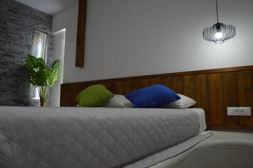 a bedroom with a bed with blue and green pillows at Kostas Studios in Faliraki