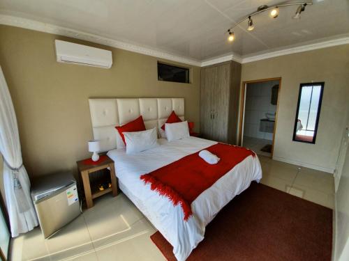 a bedroom with a large bed with a red blanket at Ubuntu Hotel in East London