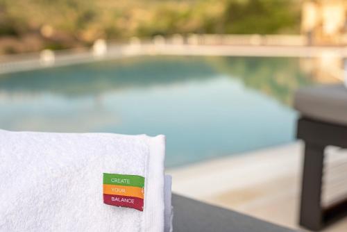 a white towel with a price tag on it next to a pool at Kedem Hotel - Adults Only in Tirat Karmel