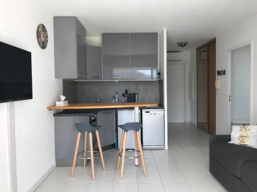 une cuisine avec un comptoir et des tabourets dans une pièce dans l'établissement AcquaMarina, à Villeneuve-Loubet
