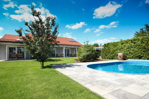 a yard with a swimming pool and a house at Apartmány MALIK in Dolní Dunajovice