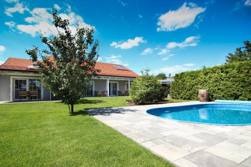 einen Hof mit einem Pool und einem Haus in der Unterkunft Apartmány MALIK in Dolní Dunajovice