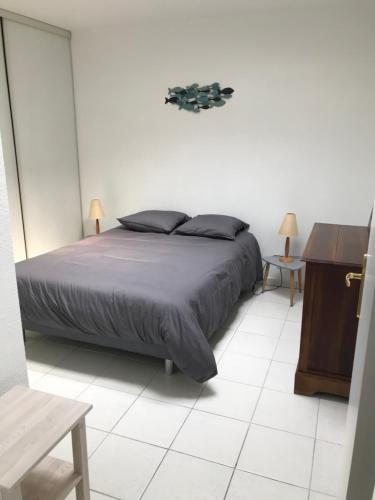 une chambre avec un lit et une table en bois dans l'établissement AcquaMarina, à Villeneuve-Loubet