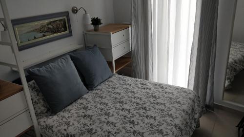 a bedroom with a bed and a dresser at Little Blue House in Marsalforn