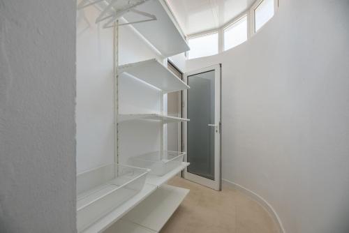 Habitación con estanterías blancas y ventana en ampio luminoso 3 camere 3 bagni giardino quiete Wi-Fi, en Costa Calma