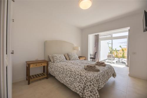 Un dormitorio con una cama y una mesa con toallas. en ampio luminoso 3 camere 3 bagni giardino quiete Wi-Fi, en Costa Calma
