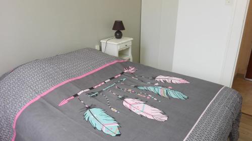 Una cama con una manta con plumas. en L'appart de lônes en Hauteville-Lompnes