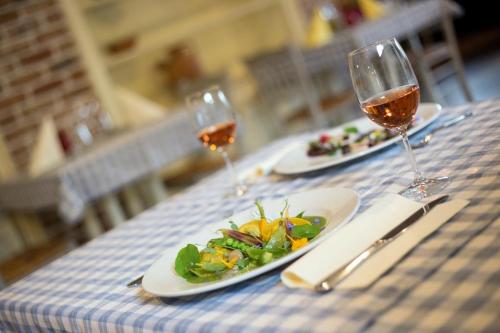 a table with two glasses of wine and a plate of food at VEGANFRESH in Medvode