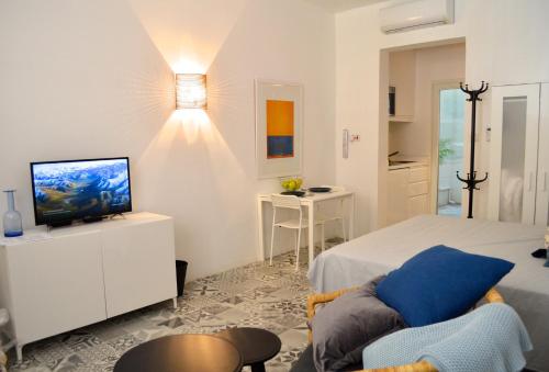 1 dormitorio con 1 cama, TV y silla en Cosy Studio Maisonette, 8min Walk to Valletta, en Floriana